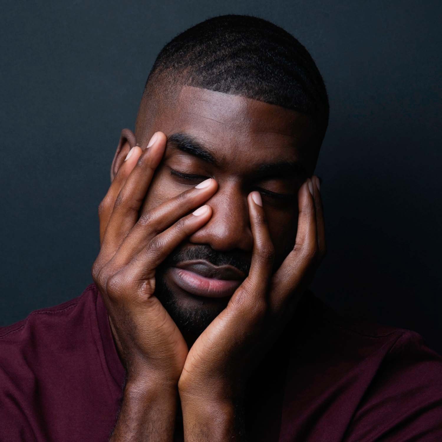 Hombre moreno tomando su rostro con sus manos