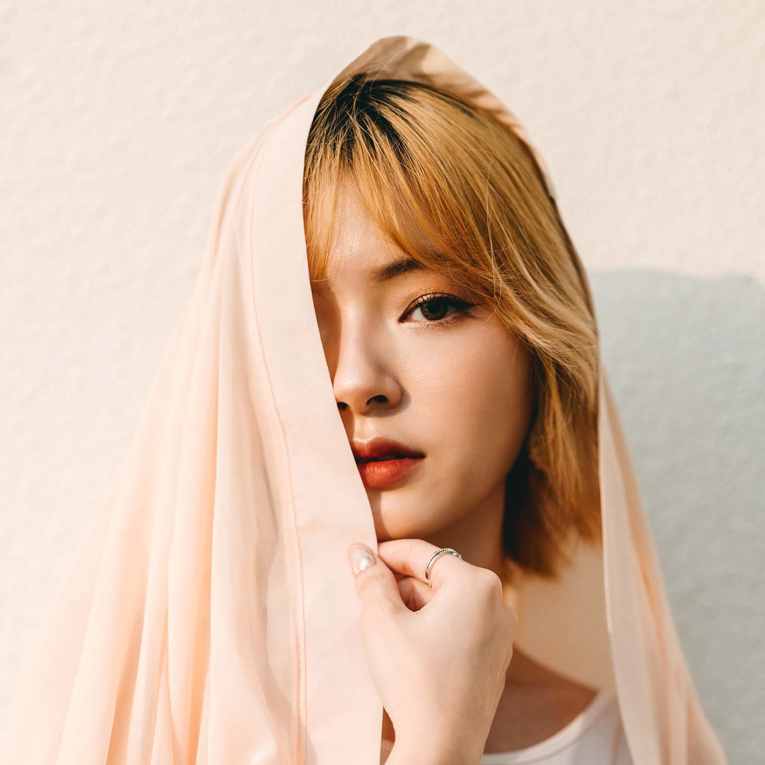 Retrato de una joven asiática sonriendo, con fondo neutro